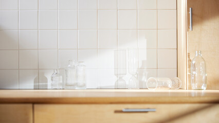 A sunny kitchen with white tile walls, a wooden table and sink.