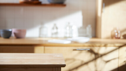 A sunny kitchen with white tile walls, a wooden table and sink.