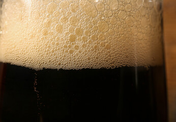 Glass of cold dark beer as background