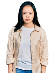 Young chinese woman wearing casual white t shirt and jacket skeptic and nervous, frowning upset because of problem. negative person.