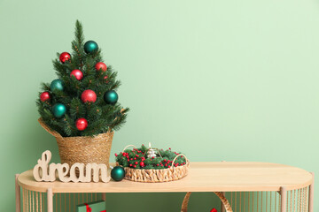 Shelving unit with Christmas tree in pot near green wall