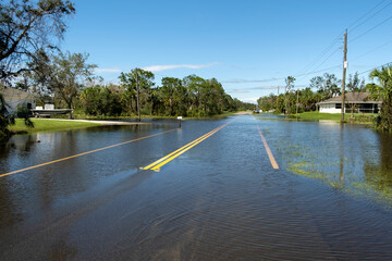 Flooded empty street after hurricane rainfall in Florida residential area. Consequences of natural...