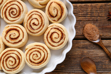Baking dish with uncooked cinnamon rolls on wooden background