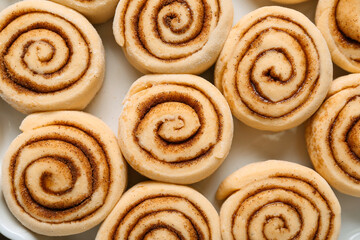 Uncooked cinnamon rolls on baking dish, closeup