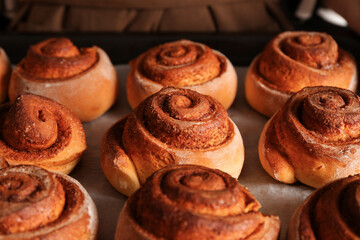 Tasty cinnamon rolls on baking tray, closeup