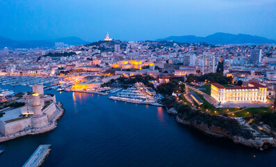 Bir's eye view of Marseille in evening with turned on city lights. Palais du Pharo visible from...