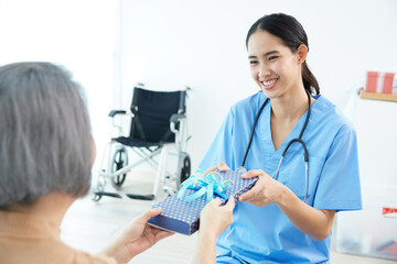 senior woman giving present or gift to her caregiver for happy birthday