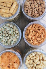 Rows of Indonesian various snacks in jars on the  table 