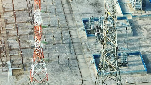 High above, a drone captures an electrical substation nestled within a lush landscape, where technology meets nature in the world of power distribution.
