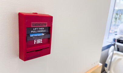 red fire alarm on a white wall, symbolizing safety and emergency preparedness