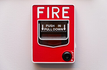 red fire alarm on a white wall, symbolizing safety and emergency preparedness