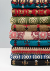 Warm rugs, stoles are stacked in  stack of several rows. Accessories for cold weather from natural material.