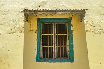 Fototapeta na wymiar a green wooden window with iron bars in an old Dutch house in Indonesia