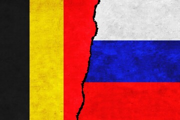 Russia and Belgium painted flags on a wall with a crack. Russia and Belgium relations. Belgium and Russia flags together