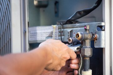 Close-up of Technician man using a wrench fixing modern air conditioning system, Air conditioning Maintenance and Repairing Concepts