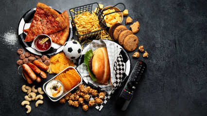 Saturated fats. Football time. TV remote control and snacks - chips, popcorn, cookies, cheese,...