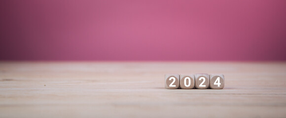 New year 2024. Square wooden blocks on pink background.