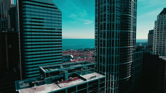 Revealing aerial Jay Pritzker Pavilion amphitheatre and The Bean between two skyscrappers in Chicago downtown USA.