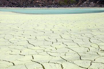 Mudcracks in the sulphur mud at White Crater or Kawah Putih, a volcanic sulfur crater lake in a caldera in Ciwidey, West Java, Indonesia.