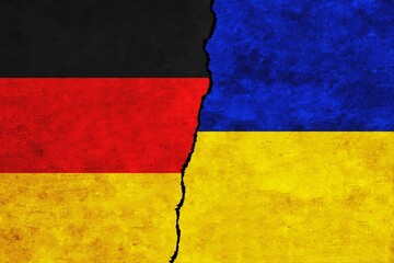 Ukraine and Germany painted flags on a wall with a crack. Ukraine and Germany relations. Germany and Ukraine flags together