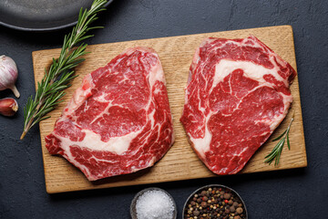 Raw ribeye steaks with savory spices