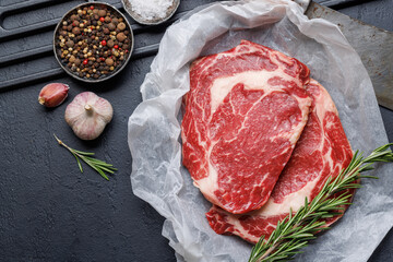 Raw ribeye steaks with savory spices