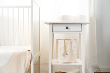 Baby bedroom interior with white wooden nightstand