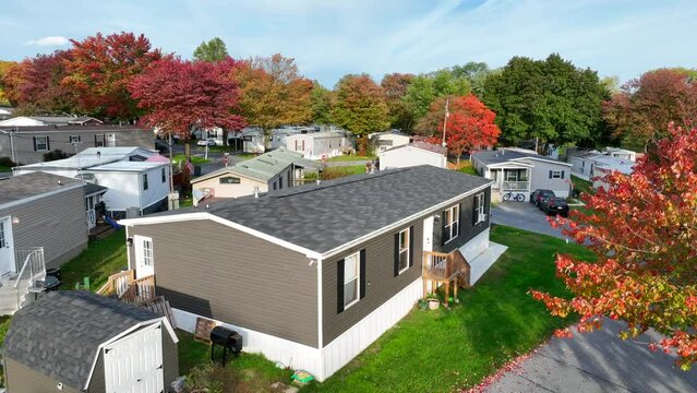 Manufactured house in mobile home trailer park in USA during autumn. Aerial rising shot.