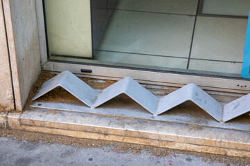 hostile design steel mounted on the edge of the curb prevents the homeless sitting