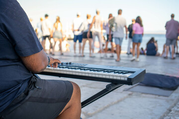A Serene Sunset Serenade: A Street Musician Melody Echoes on a Bustling Boardwalk, His Fingers...