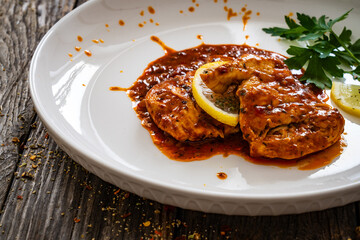 Roast chicken breast in bbq sauce on wooden table
