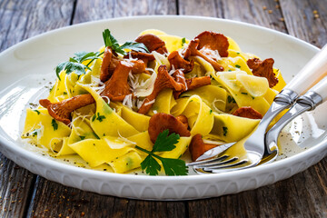 Pappardelle with chanterelle mushrooms on wooden table  © Jacek Chabraszewski