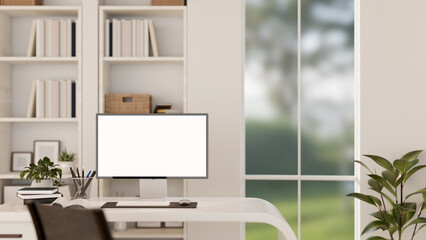 A modern white office workspace with a white-screen computer monitor mockup on a desk.