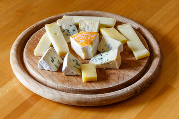 Cheese platter with different kinds of cheese on wooden table