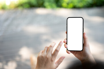 A woman using her smartphone while resting in a city public park on a sunny day. A smartphone mockup