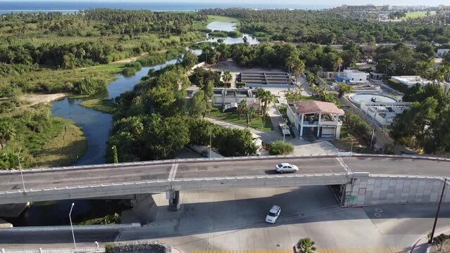 Drone footage revealing Reserva Ecologica municipal Estero in San Jose del Cabo Baja California Sur Mexico, wetlands and forest with the ocean in the distance. Starting on city then rising.