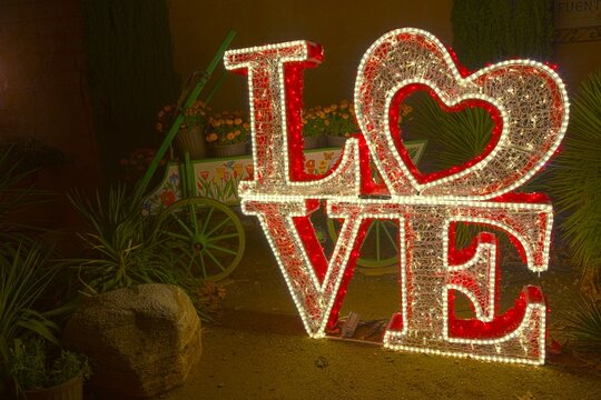 Christmas Lights, Inspirational Love Text Message, Vintage Old Wagon Cart Illuminated Background.  Tlaquepaque Spanish Village of Arts and Crafts Sedona Arizona USA
