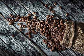 Coffee Beans Poured Wrom Bag On Vintage Wood.