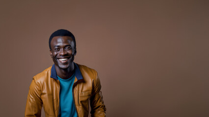 Obraz premium Young man smiling isolated on studio background. Copyspace area