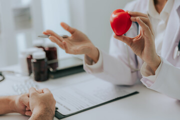 Close-up of Doctor Ying holding a heart ball and explaining the symptoms of heart disease and...