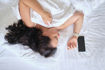 Woman lying down, serene, captured from above a calm moment. Relates to mindfulness trends,...