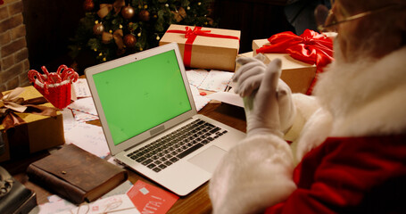  Green Screen Chroma Key. Santa Claus having a video chat using laptop computer. St Nicholas...