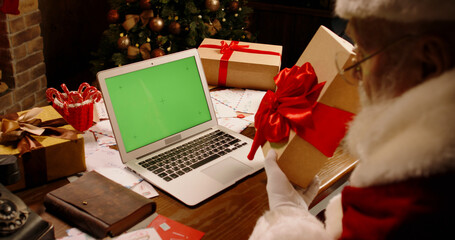 Green Screen Chroma Key. Santa Claus having a video chat using laptop computer. St Nicholas talking...