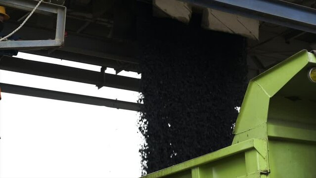 Process of pouring the mixed and homogeneous aggregate into the transport truck by opening the opening door at the bottom of the mixer with hydraulic control at the Asphalt Mixing Plant factory