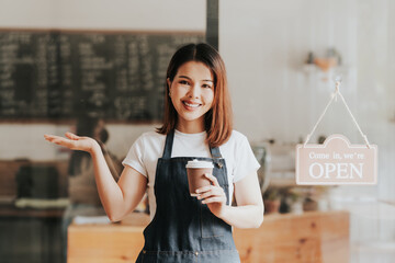 Happy excited attractive young Asian woman in denim apron, received online order in coffee shop...