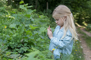 Cute little girl exploring nature. Child playing outdoors.	