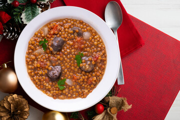 Lentils with chorizo ​​and black blood sausage. Christmas food served on a table decorated with...