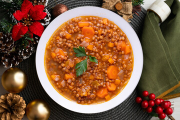 Lentils with chorizo ​​and black blood sausage. Christmas food served on a table decorated with Christmas motifs.