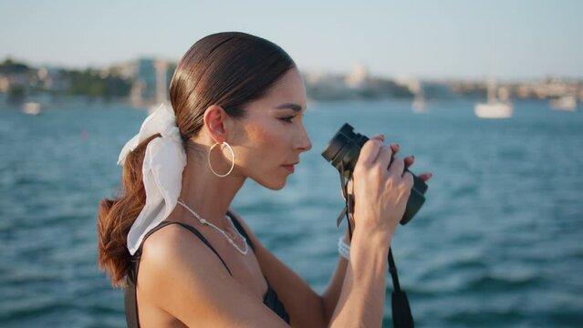 Tourist woman looking binoculars at ocean shore close up. Gorgeous girl smiling