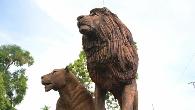 Statue of lion and lioness of Buganda kingdom culture representing clans along royal mile road in Kampala, Uganda. Low angle